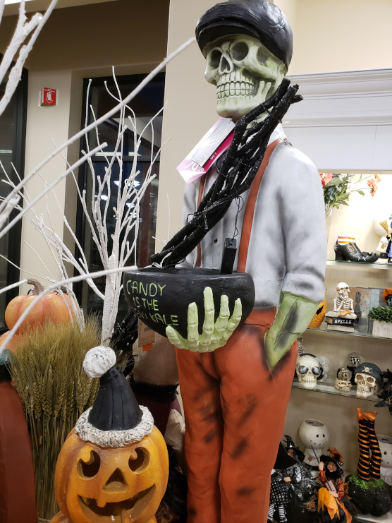 Skeleton in Suspenders Holding a Candy Bowl